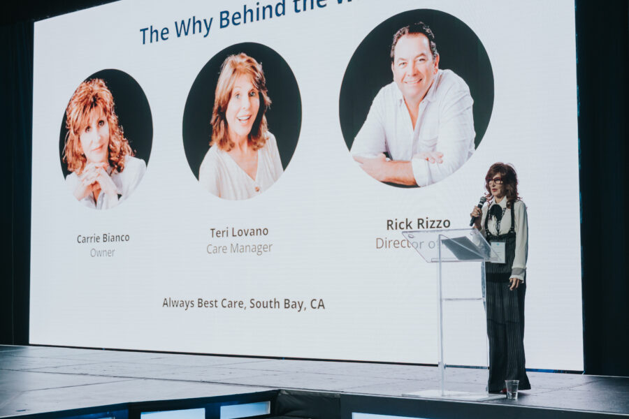 A woman speaking onstage on senior care technology