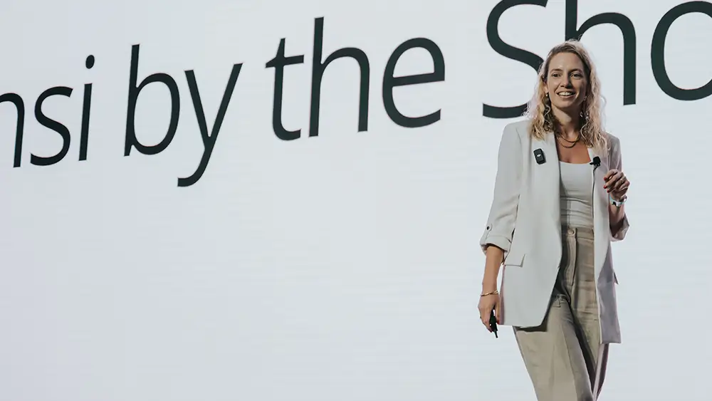 Romi Gubes speaking on stage at the Sensi By The Shore event