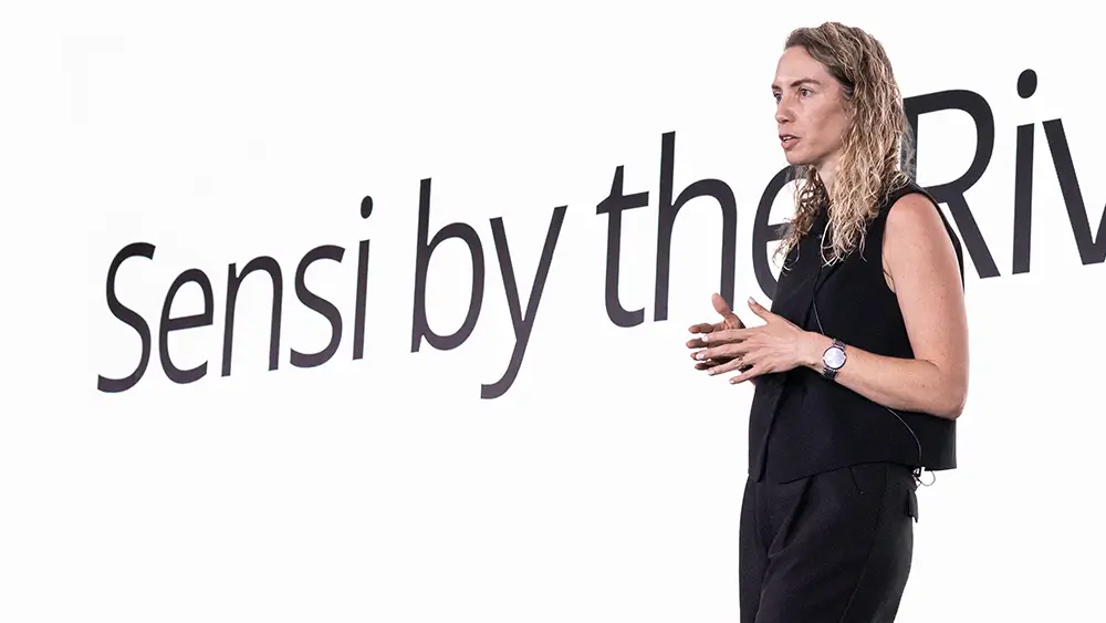 Romi Gubes speaking on stage at the Sensi By The Riviera event