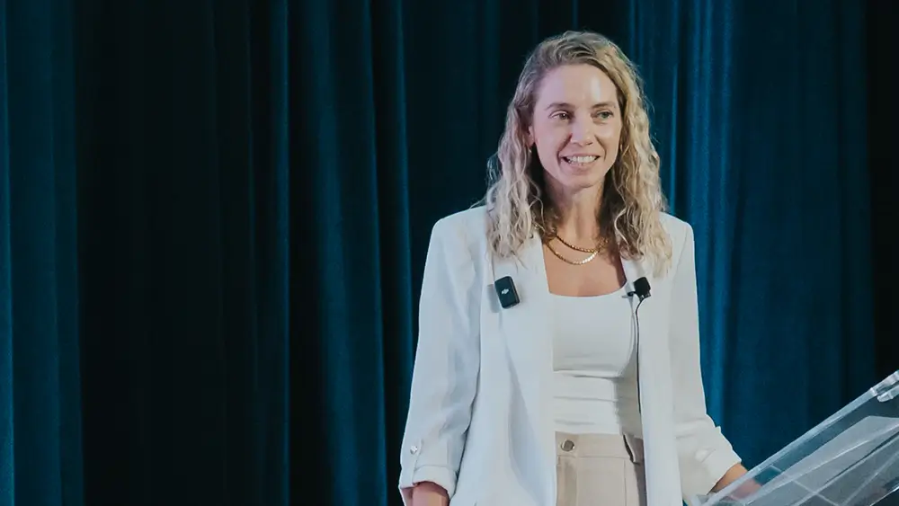 Romi Gubes speaking on stage