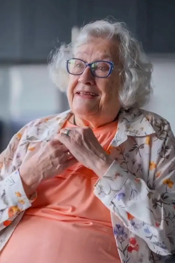 A photo of a happy, elderly white woman within an independent living facility